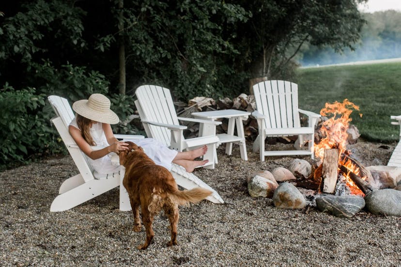 white adirondack chairs around a campfire